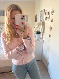 Strickjacke mit Blütenknöpfen und Schleifen